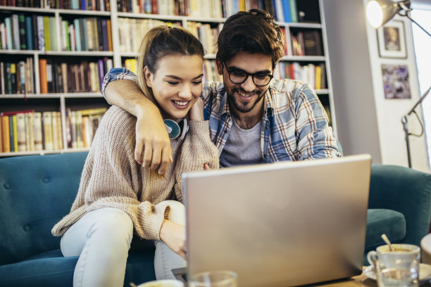 一对夫妇用笔记本电脑在咖啡馆休息，喝着咖啡。图片下载