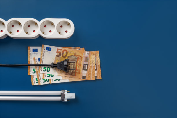 50欧元钞票上的电源插头、电源插条和蓝色背景的紧凑型荧光灯灯泡。高能源成本的概念。增加电力成本。电力危机和通货膨胀。图片下载