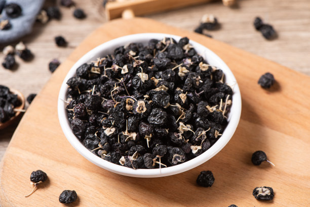 黑枸杞或黑枸杞在盘子上的桌子。图片下载