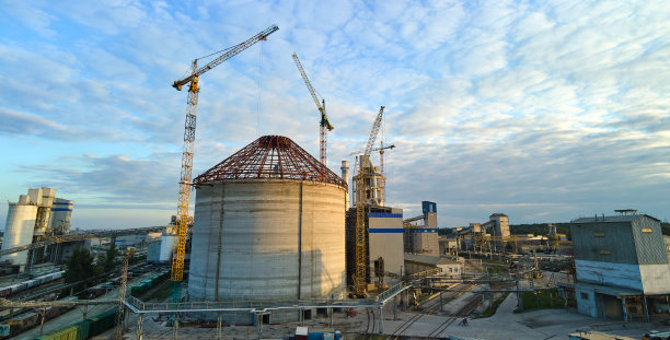 工业生产区正在施工的水泥厂鸟瞰图，有高大的混凝土厂房结构和塔吊。制造和全球产业理念。图片下载