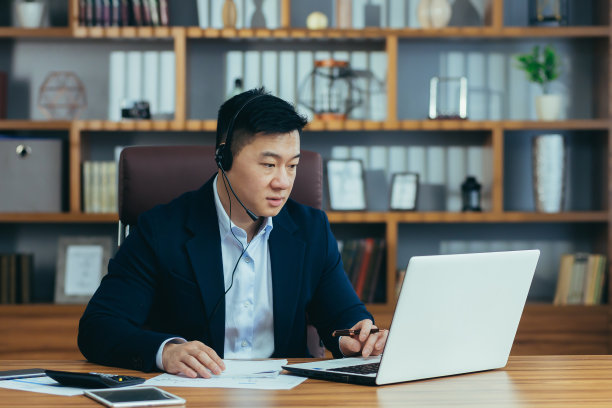 亚洲商业老师在线教授学生，使用耳机和笔记本电脑进行视频通话，大学讲师图片下载