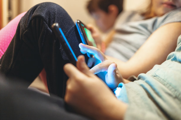 手里拿着手机的孩子。图片下载