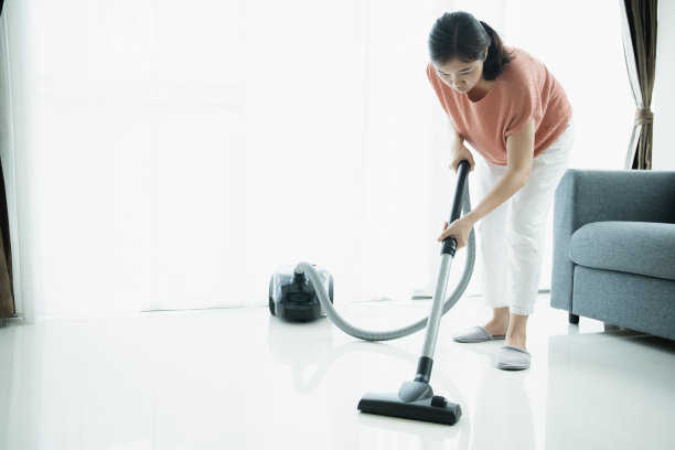 女管家用吸尘器清洗沙发。图片下载