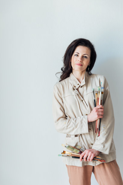 美丽的女艺术家手里拿着画笔，用颜料作画图片下载