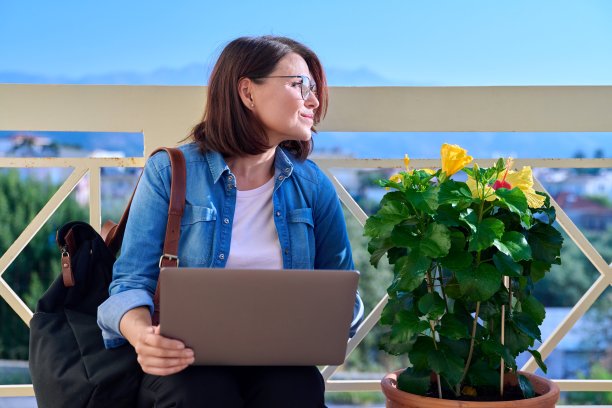 自信、严肃、成熟的商业女性在户外带着笔记本电脑。图片下载