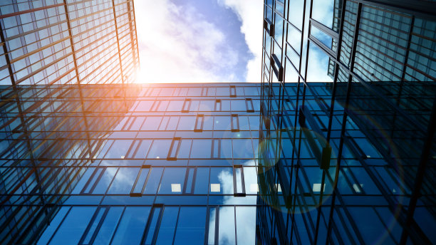 玻璃幕墙的现代办公大楼，背景是晴朗的天空。图片下载