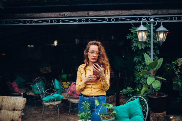 女人在家花园使用手机图片下载