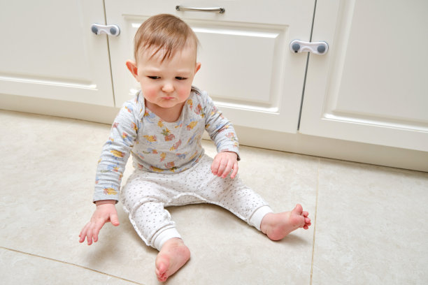 蹒跚学步的婴儿在上锁的抽屉柜附近打架。可怜的孩子和壁橱橱柜门，小孩图片下载