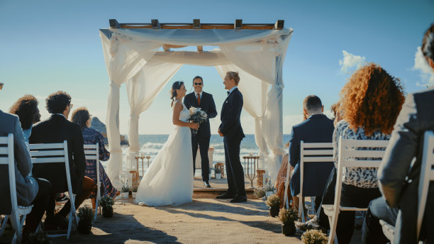 美丽的新娘和新郎在海滩上的户外婚礼上。是浪漫情侣结婚，交换戒指，亲吻和分享庆祝活动的完美场所。图片下载