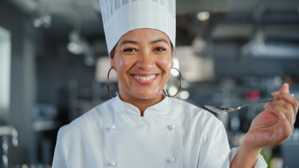 餐厅厨房:黑人女厨师准备菜，品尝食物和享受它的肖像。专业烹饪，美味，正宗，传统的食物，使用健康的食材的食谱图片下载