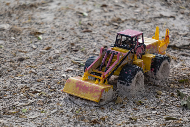 塑料玩具车损坏，遗弃在沙子里图片下载