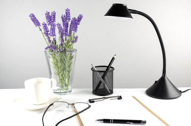 灰色桌子上有木制剪贴板、图表、台灯和办公附件。图片下载