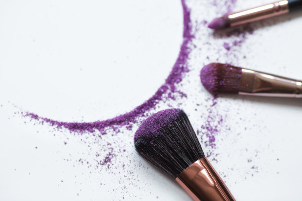 眼影和化妆刷在白色背景上突出显示。美容行业的框架。美的概念和自我护理。图片下载