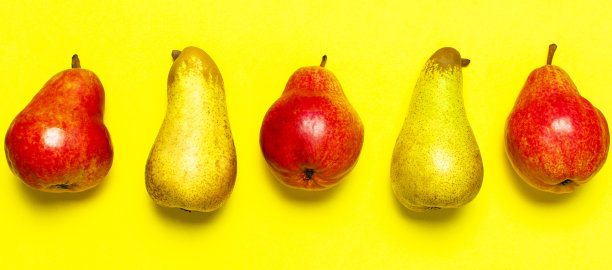 多汁的成熟新鲜的绿色和红色的梨在黄色的背景平铺上俯视拷贝空间。创意背景与梨和绿叶。水果背景，有机健康食品。收获的概念图片下载