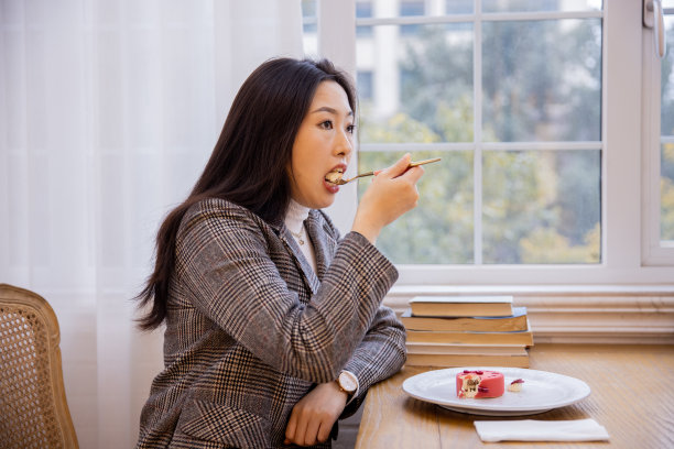 年轻的亚洲女性在餐厅吃蛋糕图片下载