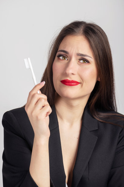 女人拿着白色的牙刷在面前图片下载