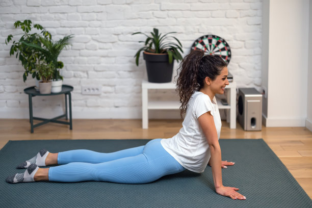 年轻女子在室内练习瑜伽的照片。美丽的女孩在课堂上练习瑜伽。图片下载