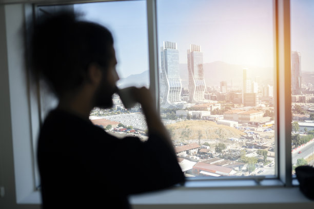 商人在窗边喝咖啡。他在考虑办公室里的一个新项目图片下载