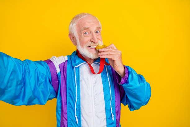 照片的爷爷退休老人胡子锻炼活动训练暖出实践奖奖牌孤立在黄色的背景图片下载