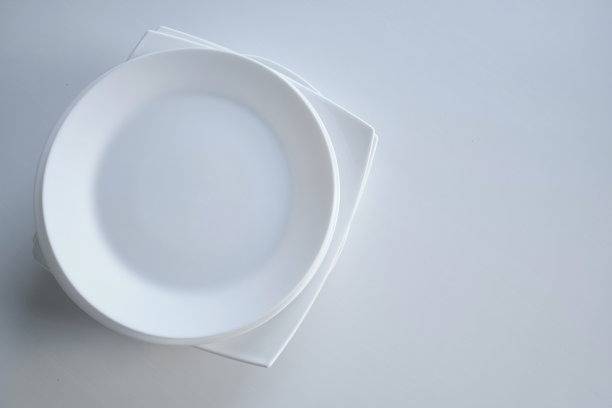 一堆白色干净的盘子放在明亮的背景上。车牌特写图片下载