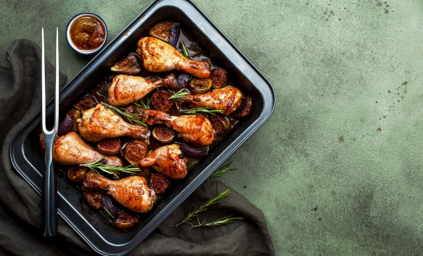 烤鸡腿，用香醋腌制的甜无花果和洋葱做的鸡腿，放在黑色烤盘上，生锈的绿色桌子背景，俯视图图片下载