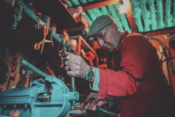 成熟的人在虎钳上用力拧紧管子图片下载