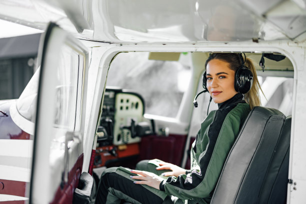 高兴的成年女机长，在驾驶舱操纵着飞机图片下载