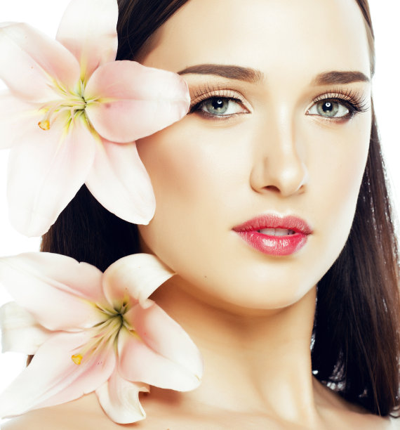 年轻迷人的女士close with hands on face孤立的花百合褐发水疗裸妆宏图片下载