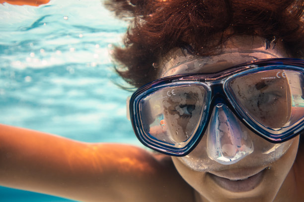 一个戴着潜水镜的男孩跳进了游泳池图片下载