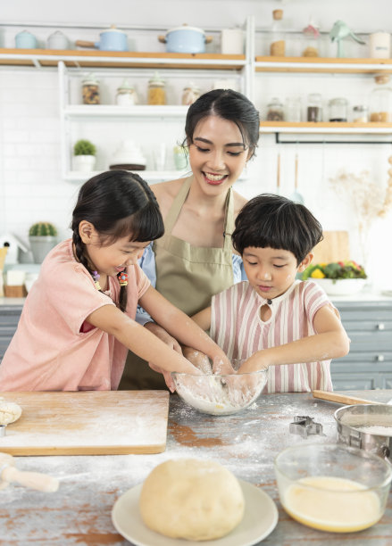 快乐的亚洲家庭在家里的厨房里做饭。一起享受家庭活动。图片下载