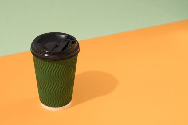 绿色生态纸咖啡杯在橙色和绿色的背景与复制空间，模型。可持续食品包装的概念图片下载