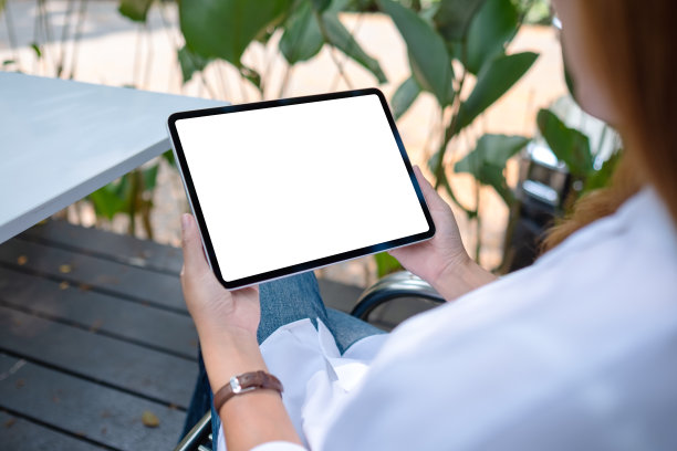 模拟图片，一个女人拿着数码平板电脑与空白的桌面屏幕在户外图片下载