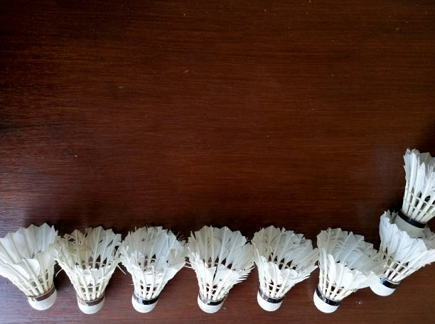 羽毛球放在棕色的木制背景图片下载