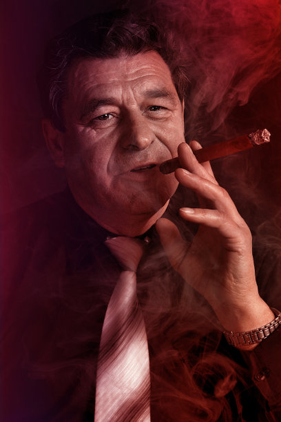 在俱乐部抽雪茄的英俊成熟男子，特写肖像图片下载