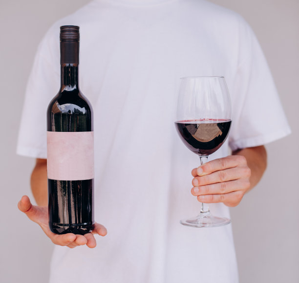 男人手里拿着酒杯和一瓶红酒图片下载