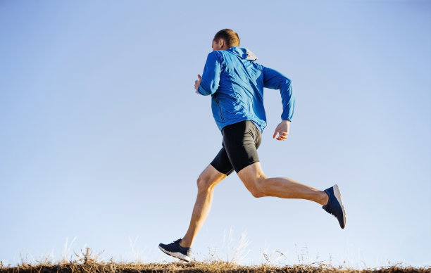 男性跑步者跑步的背景是蓝天图片下载