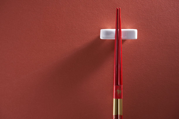 筷子在筷子休息对红色背景图片下载