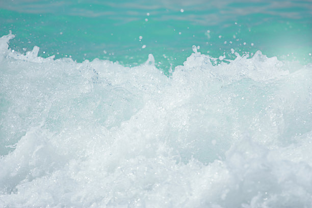 海浪拍打着海岸，激起水和白色的泡沫。图片下载