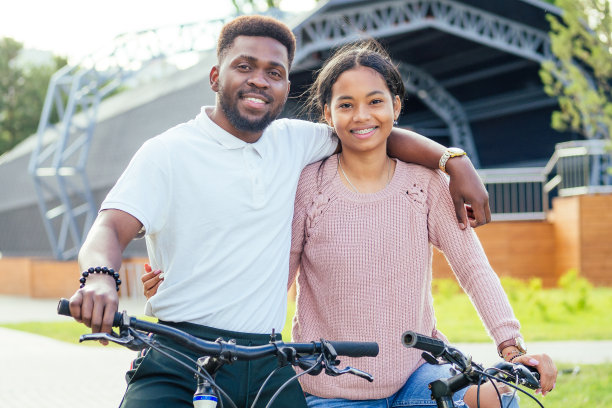 混血夫妇在手机app上骑自行车图片下载