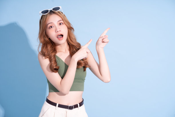 美丽年轻的亚洲女人在蓝色背景，暑假的概念图片下载