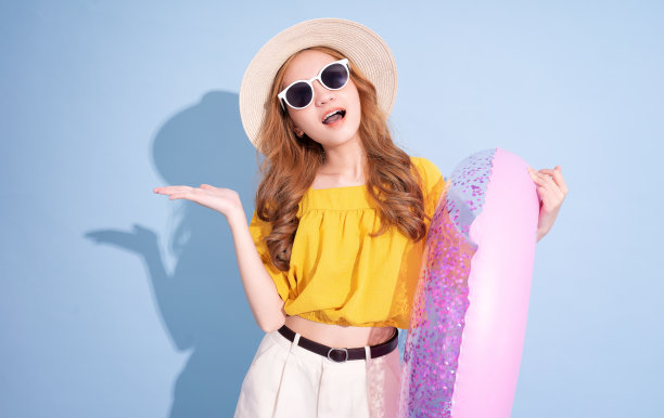 年轻的亚洲女孩肖像在蓝色背景，暑假的概念图片下载