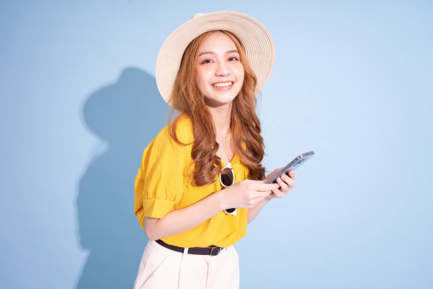 年轻的亚洲女孩肖像在蓝色背景，暑假的概念图片下载