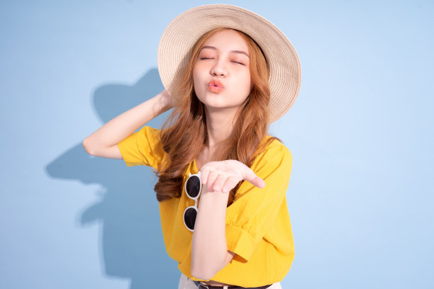 年轻的亚洲女孩肖像在蓝色背景，暑假的概念图片下载