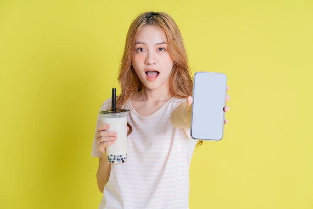 黄色背景的年轻亚洲女孩喝奶茶的形象图片下载
