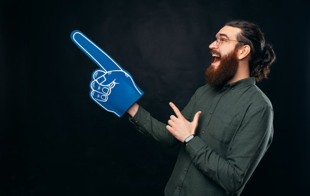 全景照片的胡子男子指着一个蓝色风扇泡沫手套。图片下载