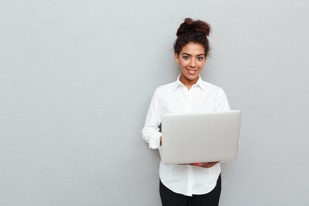 非洲开朗的女商人站在灰色的墙上图片下载