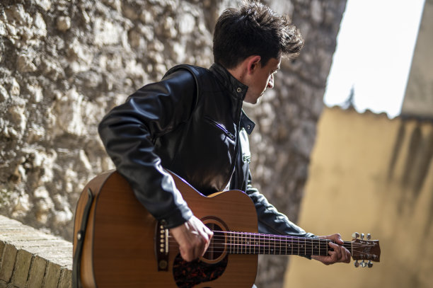 男孩在楼梯上弹吉他图片下载