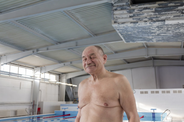 一位老人在一个退役的体育中心的游泳池里积极地从事游泳和运动。图片下载