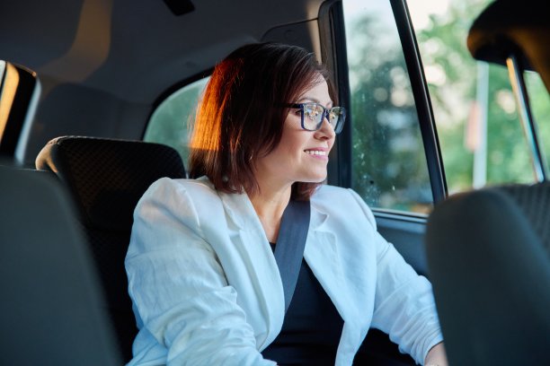 商务高雅中年妇女的肖像在汽车后座的乘客座位图片下载