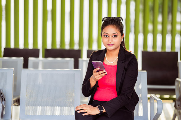 在公交车站用手机的女人图片下载